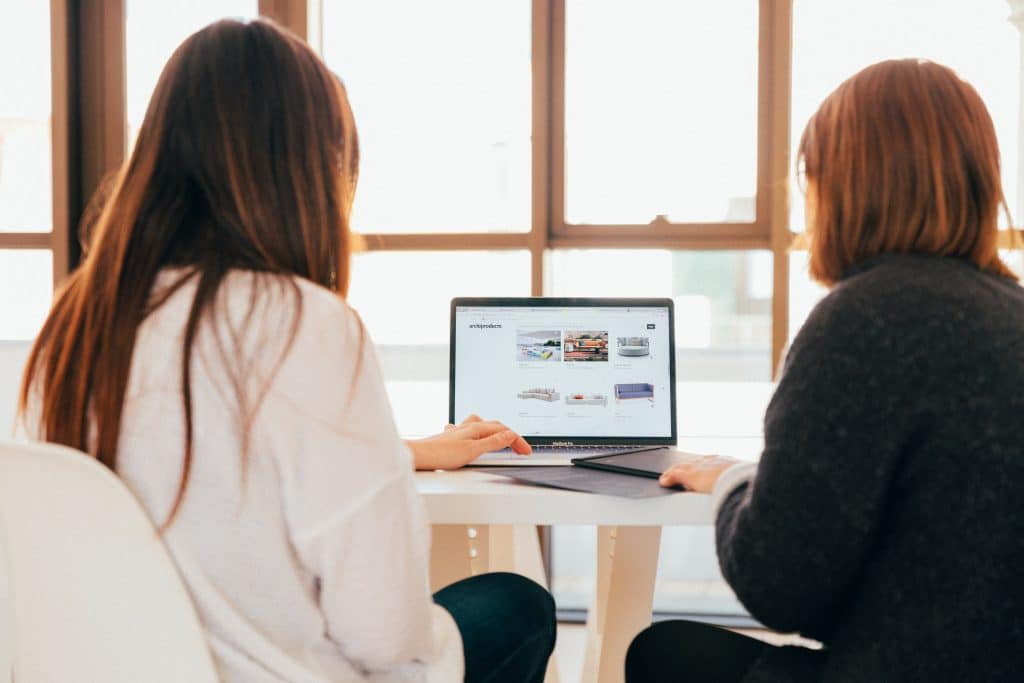 Mulheres trabalhando em um computador para entender o que é infoproduto e como abrir uma empresa como essa