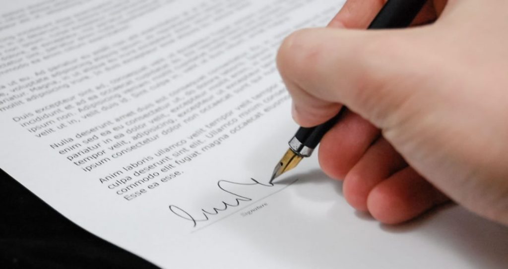 Empreendedor assinando documentos na junta comercial como parte do processo de como criar um CNPJ